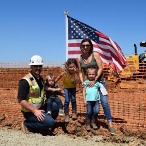 image of teichert employee with family standing in front of american flag