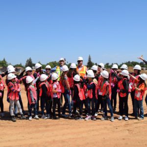 group of school children in field wearing safety vests